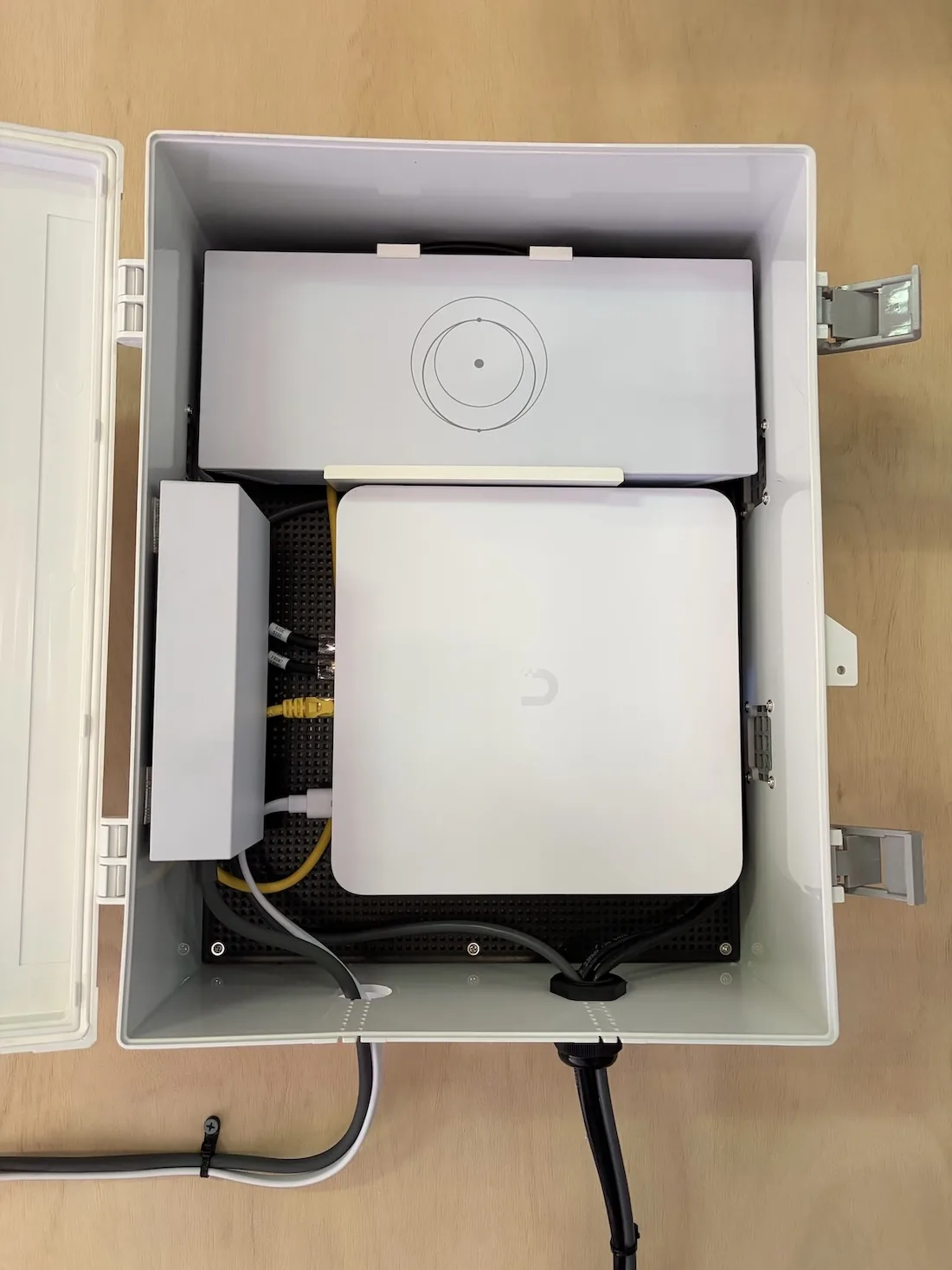 Outdoor enclosure with NVR and Starlink router for remote surveillance.